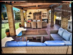 马尔帕尔蒂达德卡塞雷斯Casa Rural La Piedra De Juana的一个带蓝色沙发和桌子的庭院