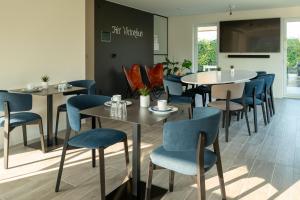 尼乌波特特尔尼尔住宿加早餐旅馆的一间配备有桌子和蓝色椅子的用餐室