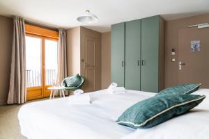 莱鲁斯Domaine du Mont-Saint-Jean的卧室设有一张白色大床和一扇窗户。