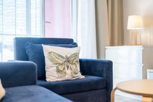 科沃布热格Przystań Koło Brzegu的客厅里蓝色椅子上的蝴蝶枕头
