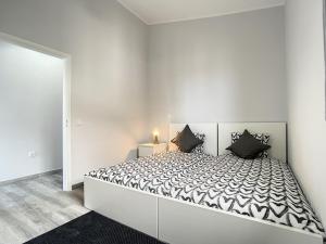 卡尼萨尔Casa da Avo by Atlantic Holiday的白色卧室配有一张带黑色枕头的大床