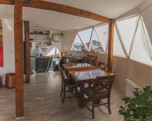 纳塔列斯港Domos by Toore Patagonia的厨房以及带桌椅的用餐室。