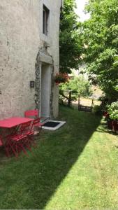 Le NoyerLa Suite Lou的大楼院子中的红色桌子和椅子