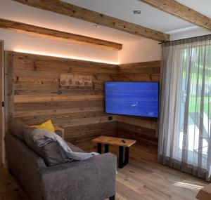 卡纳泽伊Luxury Chalet Orchidea -SPA Privata的客厅设有木墙和平面电视。