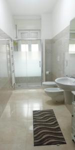 马丁纳弗兰卡Bed & breakfast dei lecci的浴室设有2个卫生间、水槽和淋浴。