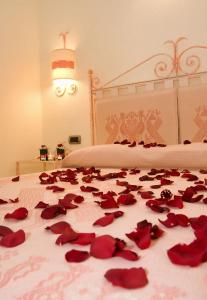 阿尔布斯Hotel Soffio di Vento的一张床上有红色玫瑰花瓣的床