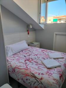 科斯拉达Hostal San Pedro的一张带红白毯子和窗户的床