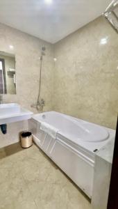 海防Minh Anh Hotel & Apartment的浴室配有白色浴缸和水槽