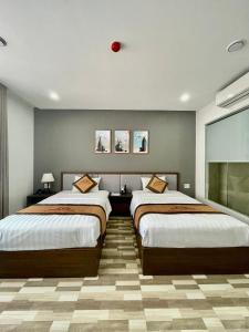 海防Minh Anh Hotel & Apartment的一间卧室设有两张床和红色球