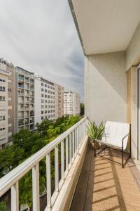 里斯本Casa Boma Lisboa - Design & Spacious Apartment With Balcony - Alvalade II的大楼内的阳台配有白色长凳