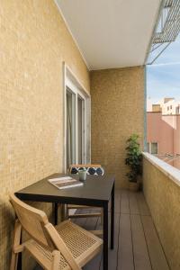 里斯本Casa Boma Lisboa - Design & Spacious Apartment With Balcony - Alvalade II的阳台配有桌椅和窗户
