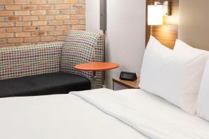 圣安东尼奥Holiday Inn Express - San Antonio Airport, an IHG Hotel的配有一张床和一把椅子的酒店客房