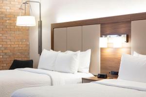 圣安东尼奥Holiday Inn Express - San Antonio Airport, an IHG Hotel的配有白色枕头的酒店客房内的两张床