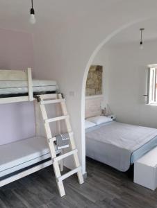 阿泰萨Minicasa nella fattoria的一间卧室设有两张双层床和梯子