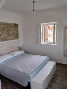 阿泰萨Minicasa nella fattoria的白色的卧室设有床和窗户