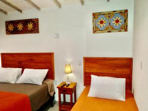 蒂拉登特斯Casa Temporada Tiradentes的一间卧室配有两张床和一张带台灯的桌子
