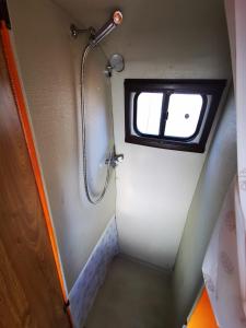 波尔蒂芒Rent a BlueClassics 's Campervan combi J9 en Algarve au Portugal的带淋浴的小浴室和窗户。