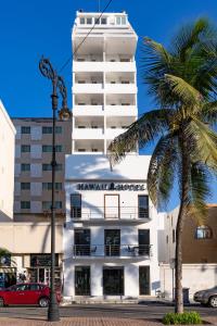 韦拉克鲁斯Hawaii Hotel Veracruz的一座白色的建筑,前面有棕榈树