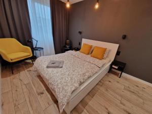 弗罗茨瓦夫Tesorio Apartment - AC, Free Parking, WiFi, Business & Family的一间卧室配有一张床和一张黄色椅子