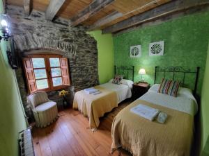 Murias de ParedesHotel Rural LA CÁRCEL的一间设有两张床的卧室,位于带绿色墙壁的房间