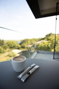 雅西Oliv Residence的一杯咖啡和桌子上的遥控器