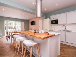伦敦Barn Hoppitt Lodge的厨房配有木制台面和白色橱柜