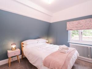 伦敦Barn Hoppitt Lodge的卧室配有白色的床和窗户。