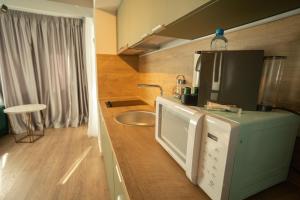 雅西Oliv Residence的厨房配有冰箱和微波炉。