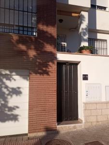 格拉纳达Apartamento Rauda 51 B, Granada的砖砌的建筑,上面有黑色的门