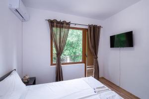 索佐波尔Къща за гости Димови的一间卧室设有一张床和一个窗口
