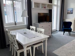奥斯赛拜-屈隆斯博恩Ferienwohnung Windlicht的白色的餐桌、椅子和电视