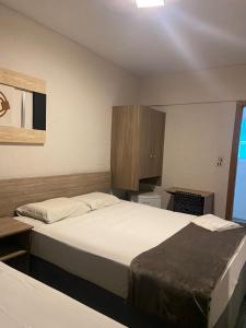 桑托斯帝王酒店的酒店客房设有两张床和橱柜。