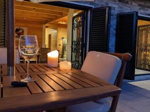 阿尔·阿尔兹Chalet de Charme, Cedars, Lebanon, Terrace Floor的一张带蜡烛和一杯葡萄酒的木桌