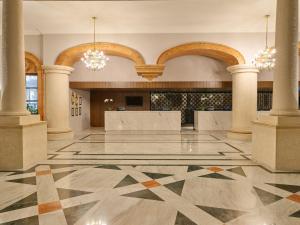 梅里达梅里达美洲庆典酒店的空的大厅,有柱子和吊灯