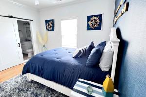 默特尔比奇Walk to the Beach-Sleeps 10 and Golfcart的一间卧室配有一张带蓝色床单的床和一扇窗户。