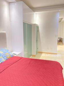 加拉加斯HATILLO SUITE的一间卧室配有一张带红色毯子的床