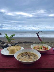努基El Retoño del Negro Gozón的海滩上一张桌子,上面放着两盘食物