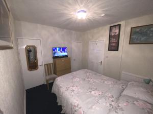 基尔温宁Private Lounge and Double Room的一间小卧室,配有一张床和电视