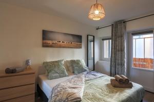 索恩河畔自由城Le Fonctionnel - TravelHome的卧室配有一张床,墙上配有电视