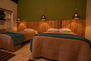 索科罗Pousada Pitauá的卧室设有两张床,拥有绿色的墙壁和灯光