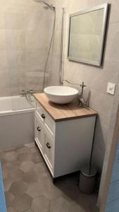 AttalensAppartement douillet, aménagé proche riviera.的浴室配有盥洗盆、镜子和浴缸