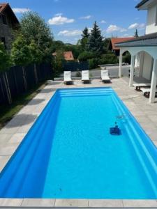 AttalensAppartement douillet, aménagé proche riviera.的一座大型蓝色游泳池,在院子里设有两把白色椅子