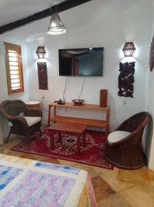 帕拉库鲁Pousada Yuste Beach Farm的客厅配有电视和桌椅