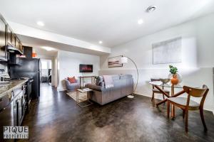 埃德蒙顿Stunning Modern Suite - King Bed - Free Parking & Netflix - Fast Wi-Fi - Long Stays Welcome的厨房以及带沙发和桌子的客厅。
