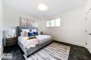 埃德蒙顿Stunning Modern Suite - King Bed - Free Parking & Netflix - Fast Wi-Fi - Long Stays Welcome的一间卧室配有一张带蓝色枕头的床和一扇窗户。