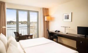 汉堡汉堡芮拉诺酒店的配有一张床、一张书桌和一扇窗户的酒店客房