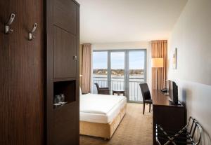 汉堡汉堡芮拉诺酒店的配有一张床、一张书桌和一扇窗户的酒店客房