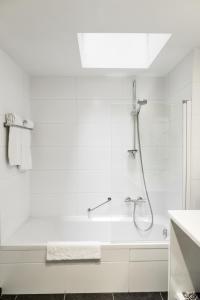 利尔Zimmerhof Hotel的带淋浴和浴缸的白色浴室