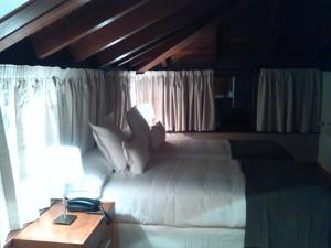 里瓦德塞利亚维拉德塞拉酒店的卧室配有白色床和木制天花板