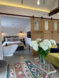 Little BudworthLuxury Barn with Hot Tub, Spa Treatments, Private Dining的客厅配有一张床和花瓶